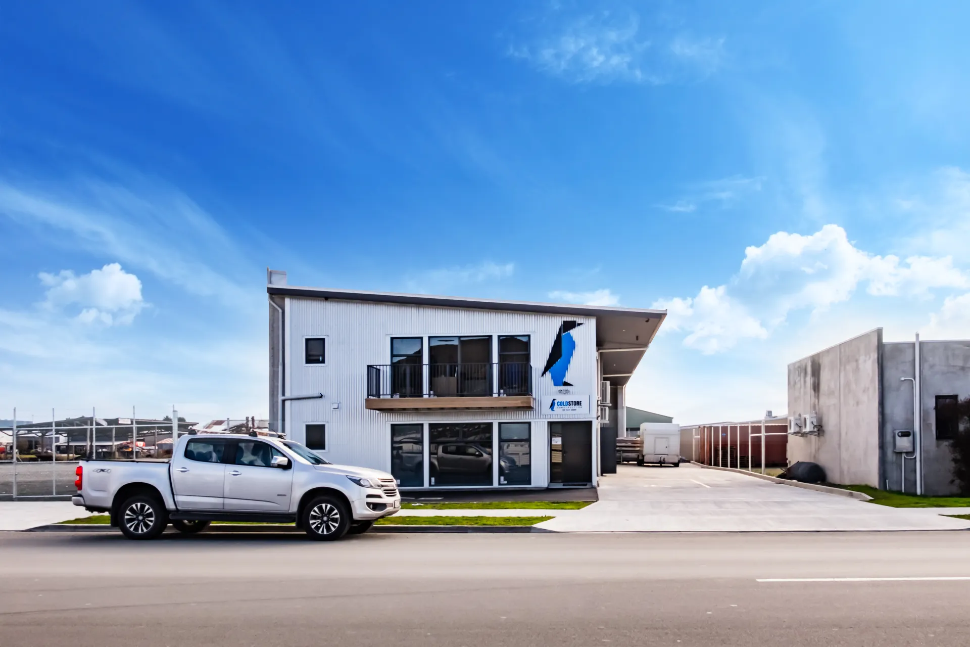 The new Coldstore Construction penguin mark on the side of the company's two-storey headquarters, with a branded ute parked out front.
